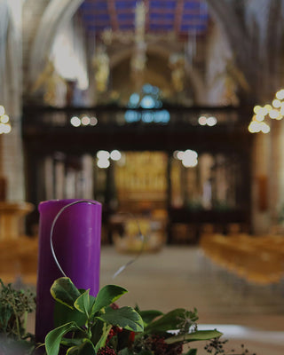 Purple Advent candle and wreath in church.